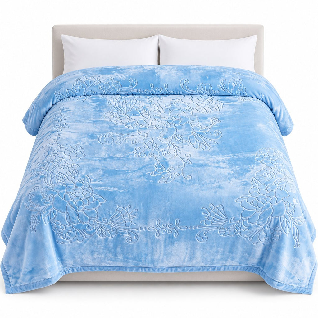 Blue embossed floral blanket on bed, white background