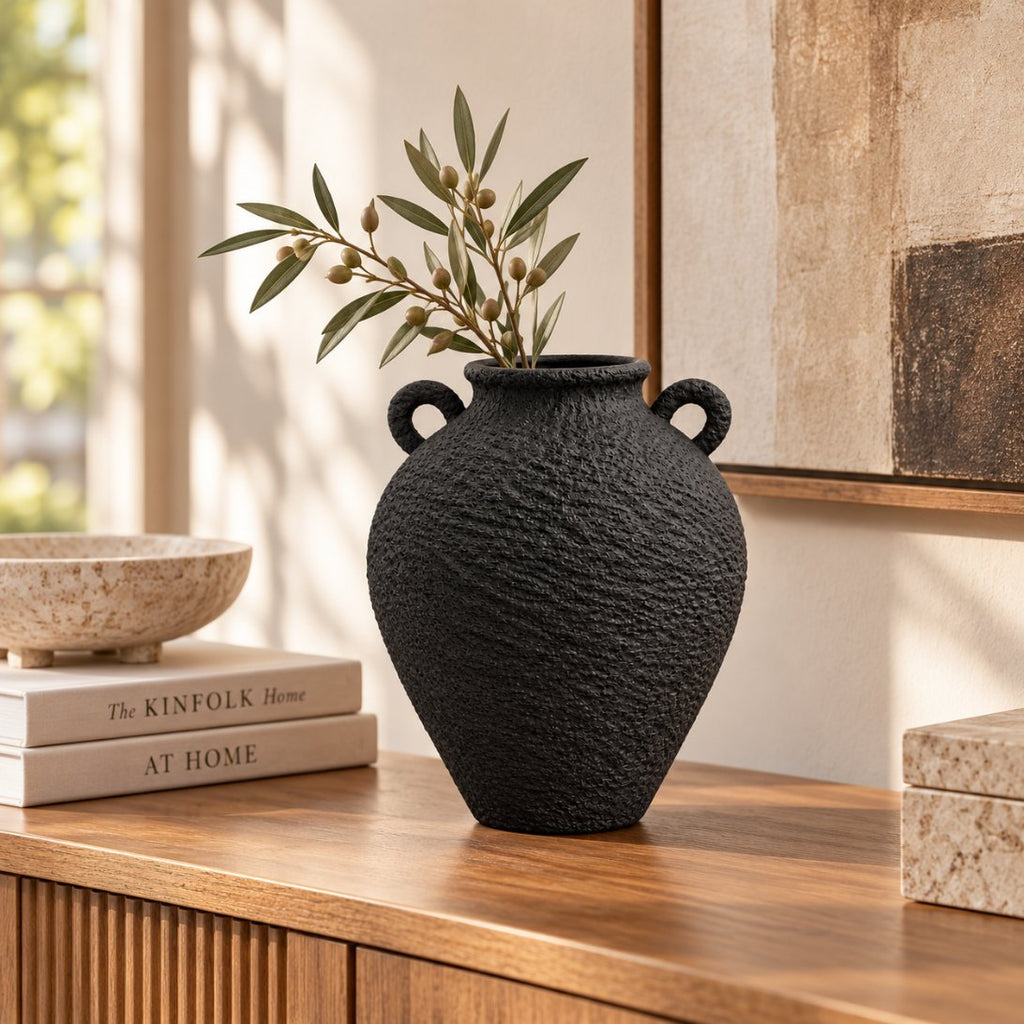 Black textured vase styled on console with olive branch