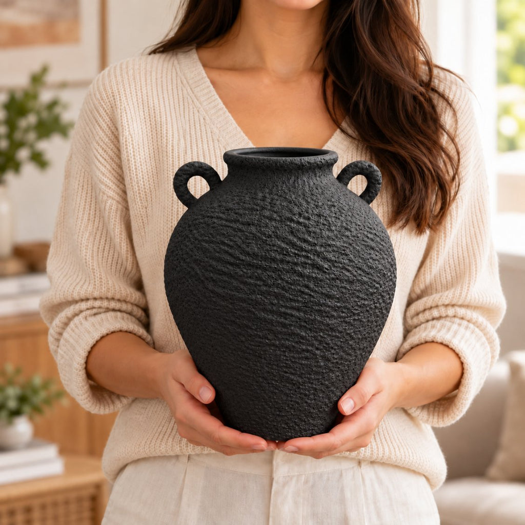 Woman holding black textured vase, accent size