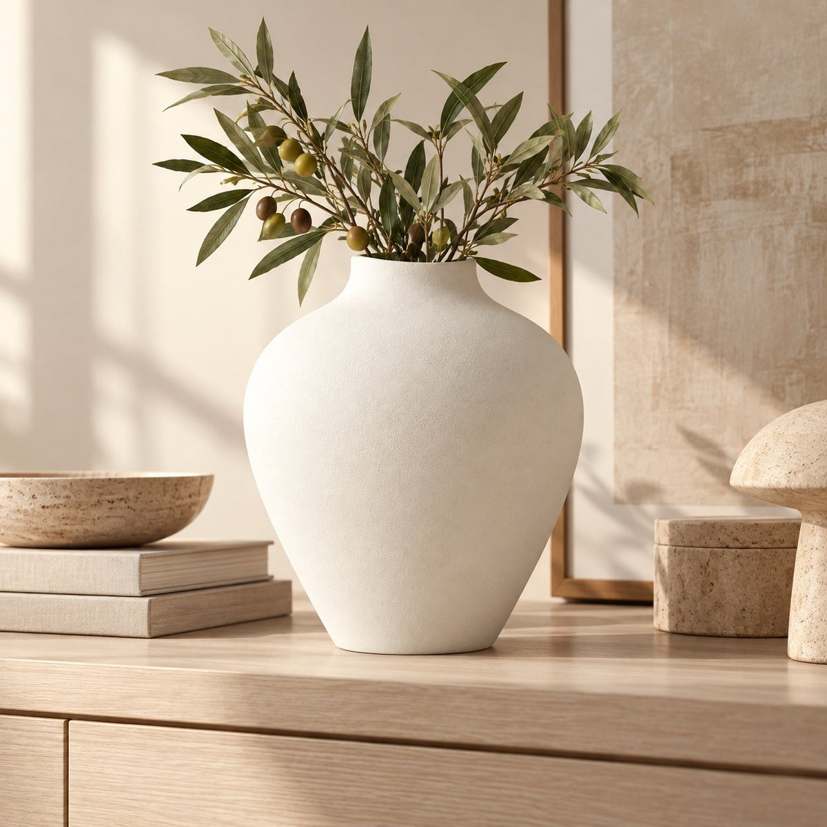 White matte vase with olive branches on console table